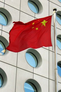 China flag with office building windows in the background